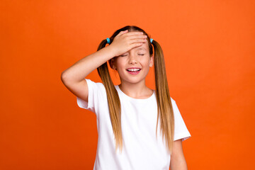 Photo portrait of charming little girl touch forehead forget dont remember wear trendy white clothes isolated on orange color background