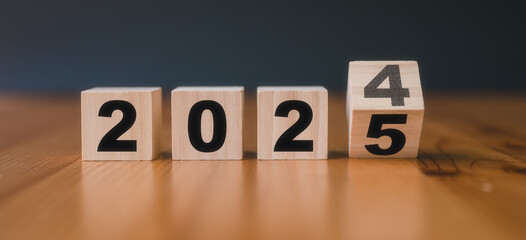 wooden cubes with the text 2024 2025 over background.translated from 2024 to 2025. new business...