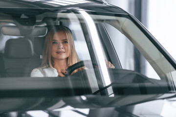 Front view, driving. Woman is sitting in a car