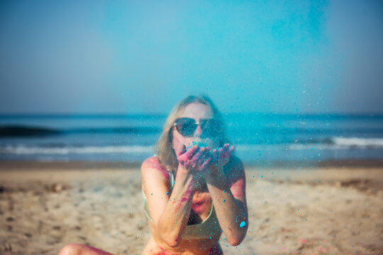 Portrait of a happy young beautiful girl at the Holi Festival of colors on the ocean in India. Smiling tourist in India at the Holi Festival