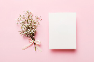 Wedding mockup with white paper list and flowers gypsophila on colored table top view flat lay. Blank greeting cards and envelopes. Beautiful floral pattern. Flat lay style - Powered by Adobe