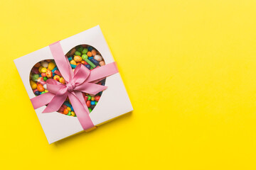 Box with sweet chocolate candies on color background, Various candy sweets. Valentines day gift box. Top view flat lay with copy space - obrazy, fototapety, plakaty