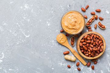 Bowl of peanut butter and peanuts on table background. top view with copy space. Creamy peanut pasta in small bowl