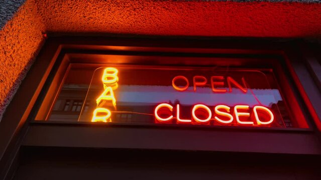 After-hours shutdown: Neon closed sign in the bar window at night