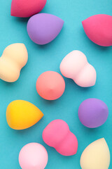 Beauty blender. Cosmetic sponge on blue background. Beauty concept. Vertical photo