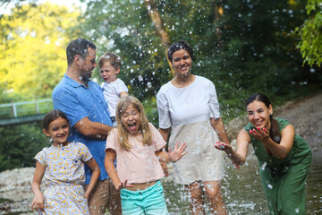 Adults and kids having fun in mountain river