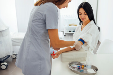 Young brunette woman in a white coat makes medical procedures
