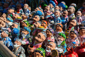 Ceramic figures of Uzbek men and women in traditional clothes. Souvenirs at showcase, gift market...