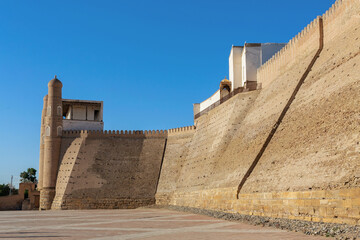 Ark of Bukhara fortification walls and main gates with light blue sky at background. Bukhara, Uzbekistan