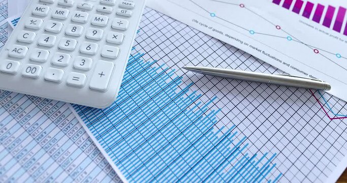 Calculator with business charts and reporting statistics on table. Planning analytics in marketing concept