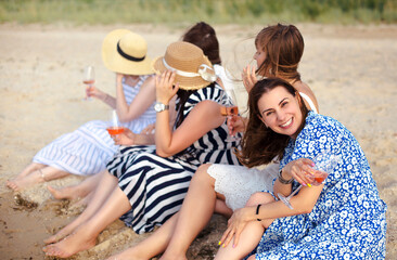 Cheerful women proposing toast on beach - obrazy, fototapety, plakaty