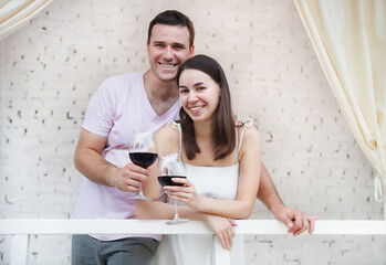 Рappy couple enjoying a glasses of red wine indoors