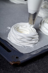 The process of making Pavlova dessert. The confectioner shapes the whipped cream with the help of a pastry bag.