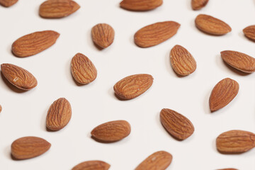 Assorted Raw Almonds Evenly Scattered on a Pure White Surface