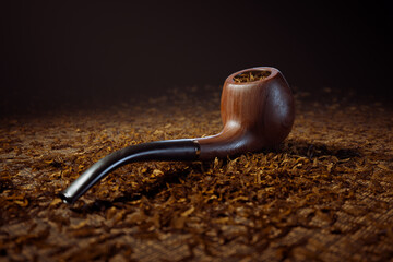 Vintage Mahogany Smoking Pipe on a Bed of Fragrant Tobacco Leaves