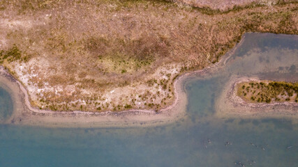 This is an aerial shot capturing the intricate curves of a serpentine shoreline where land meets...
