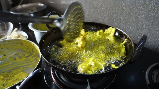 A close up shot of Indian snack called pakoda in making. A deep fried marinated potato recipe.