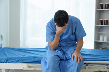 A male patient suffering from stress, migraines, eye strain, headaches, eye problems from working hard and not getting enough rest receives treatment from a doctor at the hospital.