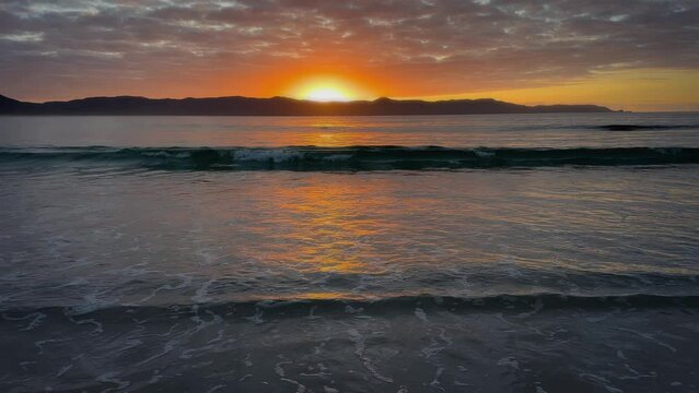 Sunset and ocean waves at Spirits Bay, Northland, New Zealand.