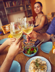 Hands of a group of people cheering with white wine