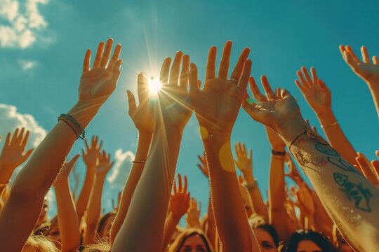 A Group Of People Celebrate Together With Their Hands Raised In A Symbol Of Happiness And Unity Against The Backdrop Of A Sunny Sky.