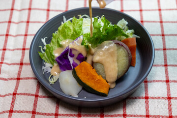ドレッシングをかけたお皿に盛り付けた蒸し野菜のサラダ