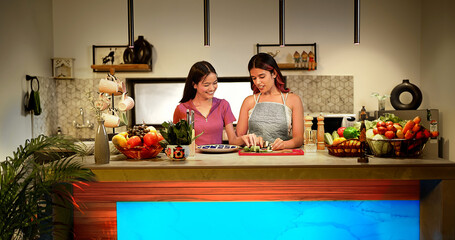 Asian Indian female gen z couple pair standing kitchen cutting slice chop board prepare healthy...