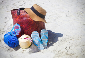 Straw hat, wather mask, beach towel, flip flops with beach bag and coconut cocktail