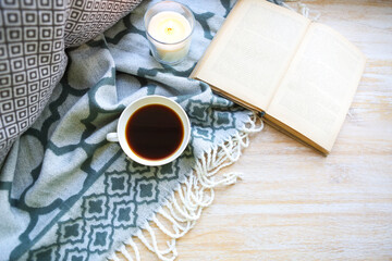 Cup of coffee, candle and book on the floor