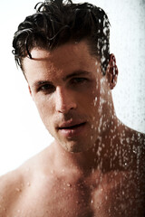 Portrait of man in shower with muscle, cleaning hair and body for morning wellness, hygiene and routine. Grooming, skincare and relax, male model washing in water with self care and calm bathroom.