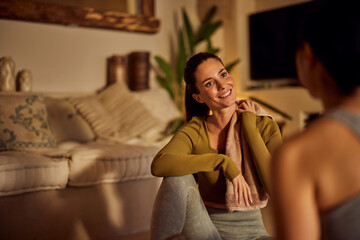 A smiling female talking to her female yoga instructor, after the yoga class.
