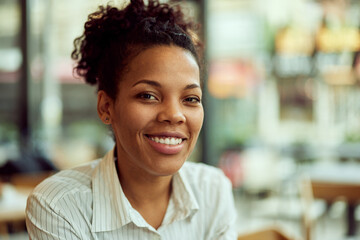 Close-up portrait of a smiling African woman, sitting at the cafe, looking beautiful.