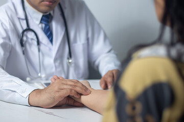 Doctor uses hand to take patient's pulse