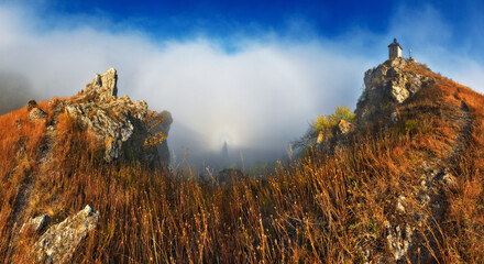 Church on the rock. Autumn landscape with fog. Nature of Ukraine
