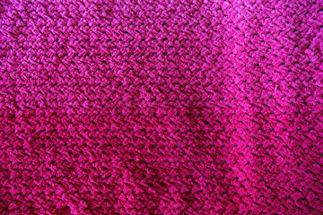 Textures of this close-up of a pink crocheted blanket.