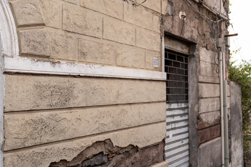 Old brick wall with windows and door of a house.