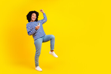 Fototapeta na wymiar Photo of cheerful positive glad girl wear trendy clothes celebrate success raise hand fist yes empty space isolated yellow color background