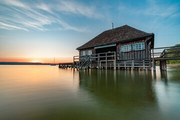 Haus am See bei Sonnenuntergang