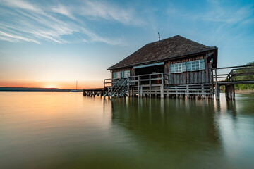 Obraz premium Haus am See bei Sonnenuntergang