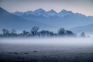 Dolomites. Mountains seen from the village Belluno, Italy. Foggy climate in the morning with a view of the Dolomites mountains