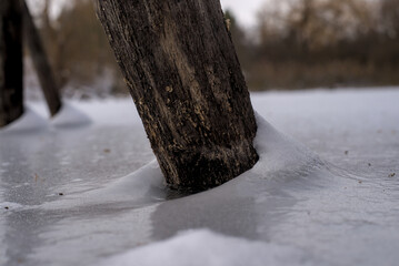 Wooden post in a frozen pond