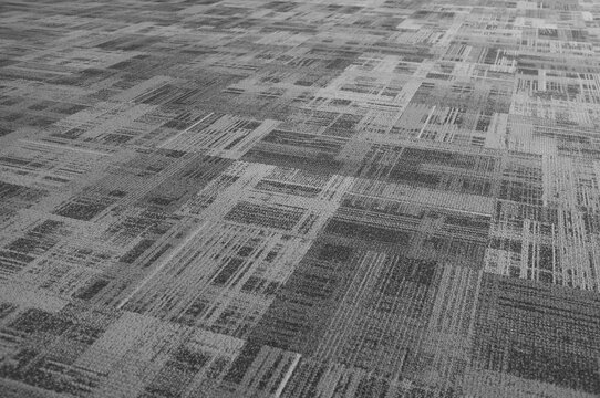 Defocus on the seamless abstract pattern of the airport carpet floor ,made of velvet and its black and white tone