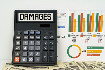 On the table are financial reports, dollars and a calculator with the inscription - damages