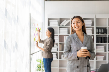 Asian businesswoman is discussing a new business project on a tablet. In a meeting, two people discuss investment projects on data charts and planning strategies. About new business