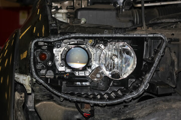 The car mechanic installs the lens in the headlight housing. The concept of a car service....