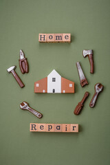 Repair or home improvement tools and a house model on a plain background