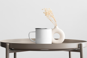 Enamel mug mockup with a gypsophila decoration on the beige table.