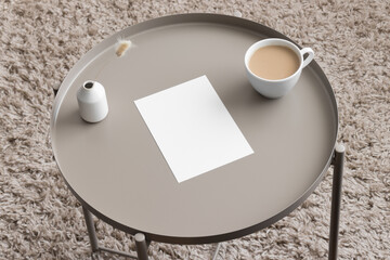 White invitation card mockup with a lagurus and a cup of coffee on the beige table. 5x7 ratio,...