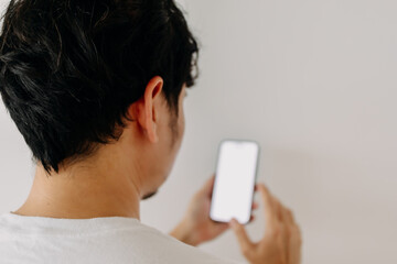 Back view of Asian man head, backside using mobile phone, showing white screen display, isolated...