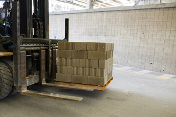 Monta carga, transportando ladrillos de cemento ecológico  - obrazy, fototapety, plakaty